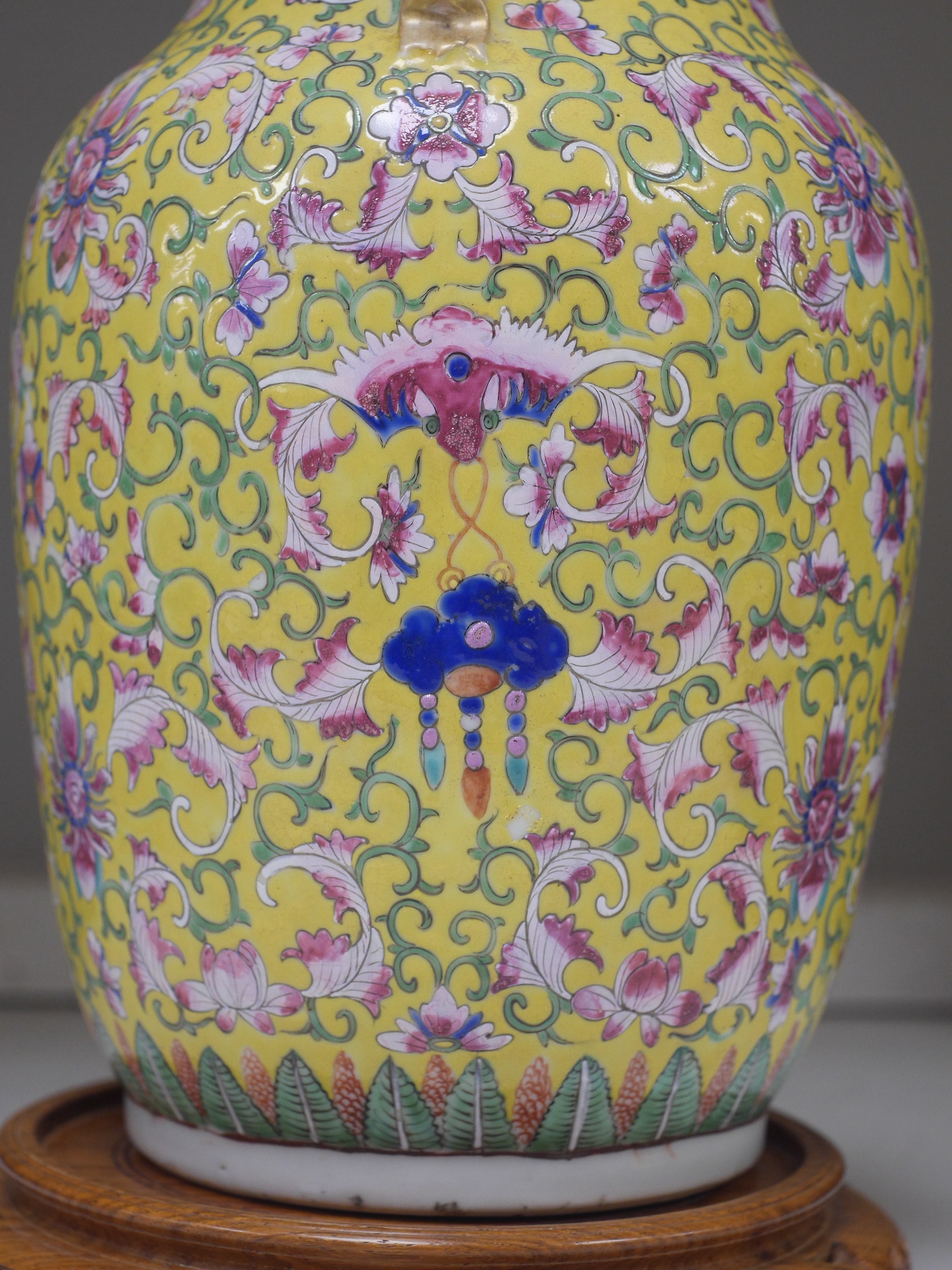 A late 19th century Chinese yellow ground porcelain vase, with gilt chilong handle, decorated with flowers and tendrils, iron red bands to the scalloped neck (including two stands), 35cm high. Condition - chip to top edg